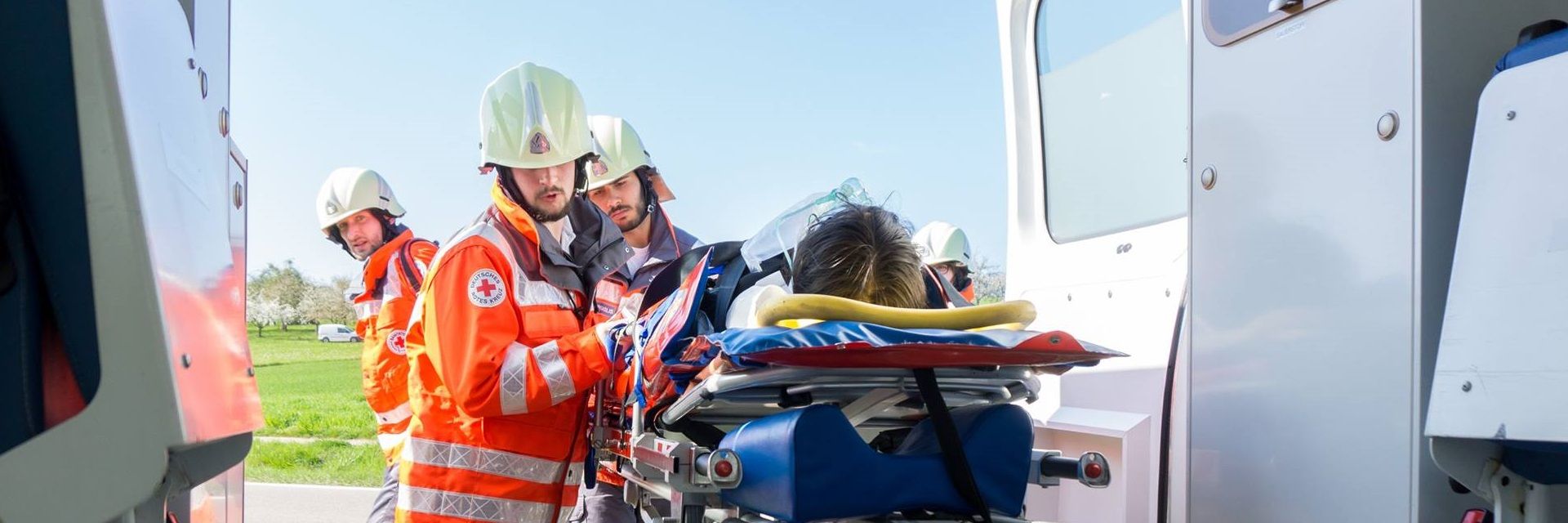 Foto: Mitarbeiter des DRK verbringen einen Patienten in einen Krankenwagen (Übung)